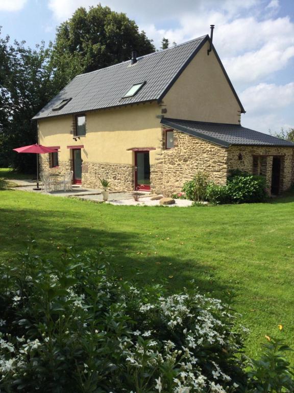 una gran casa de piedra con techo negro en Gîte de la Fresnais, en Epiniac