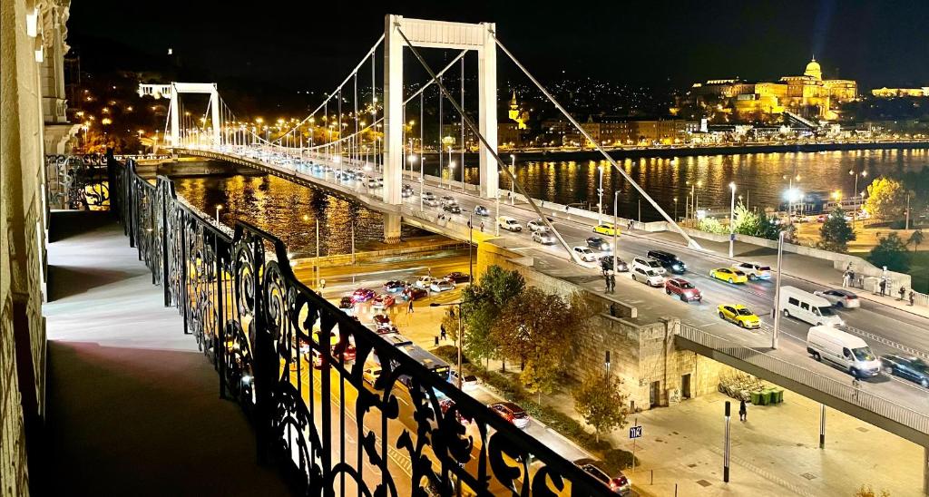 eine Brücke über einen Fluss in der Nacht mit Autos in der Unterkunft Luxury Penthouse in Downtown in Budapest