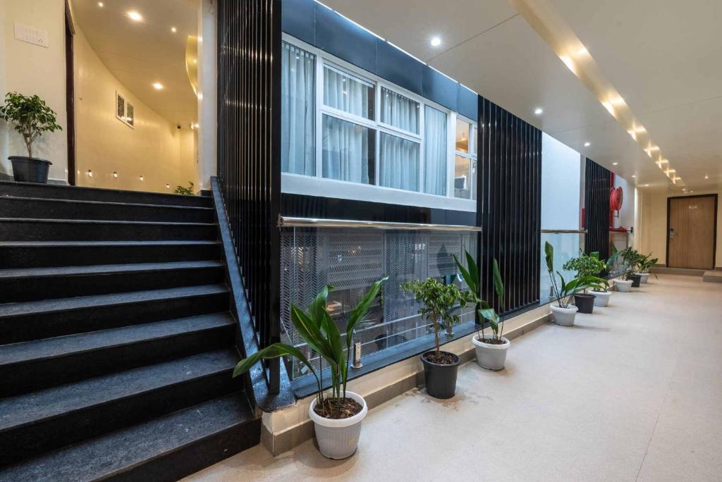 a lobby with potted plants and stairs in a building at HOTEL ROI-KI in Shillong