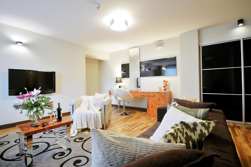 uma sala de estar com um sofá e uma mesa em DOBRUK APARTAMENTY GRZEGORZ apartamenty prywatne w budynku hotelu Royal Tulip Sand em Kolobrzeg