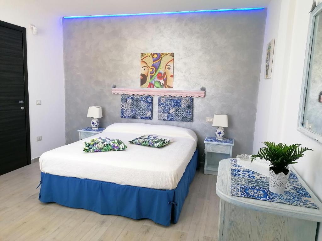 マリーナ・ディ・パルマにあるSciascia Apartmentのベッドルーム1室(ベッド1台、ナイトスタンド2台、テーブル2台付)