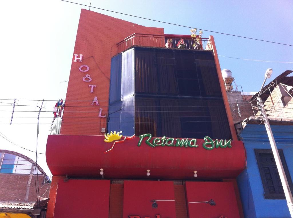 a building with a restaurant sign on the side of it at Hostal Retama Inn in Huancayo