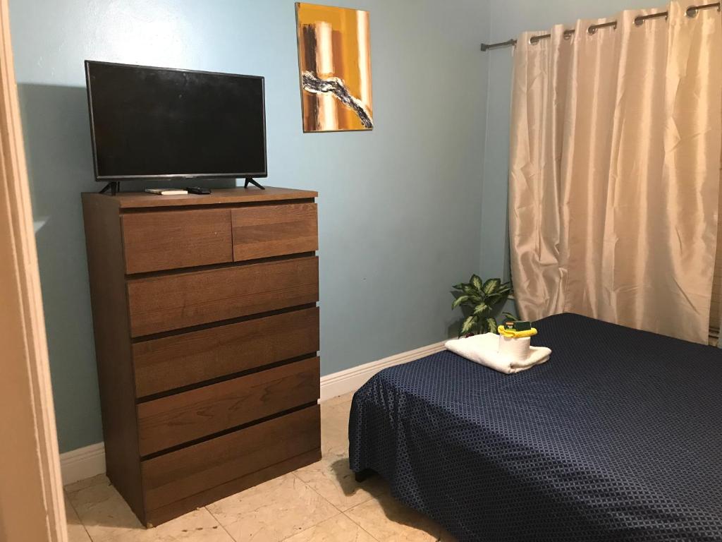 a bedroom with a dresser with a television on it at Cozy Guest House Florida, Tamarac in Tamarac