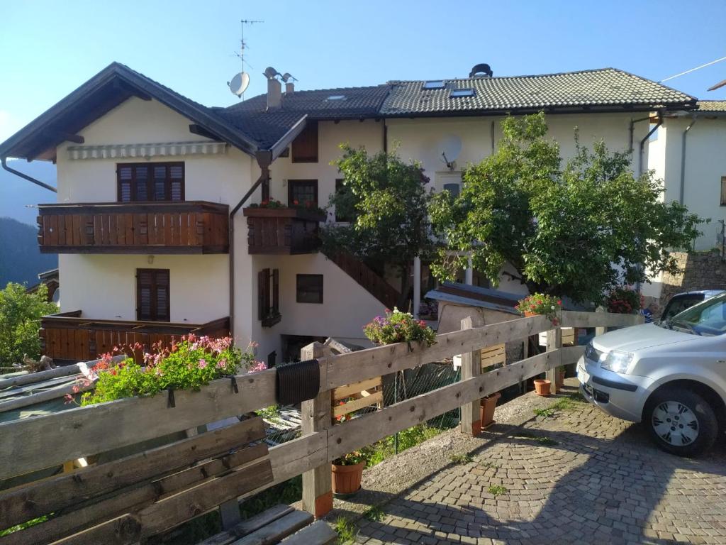 una casa con una valla y un coche aparcado delante en Casa in valle, en Sicina