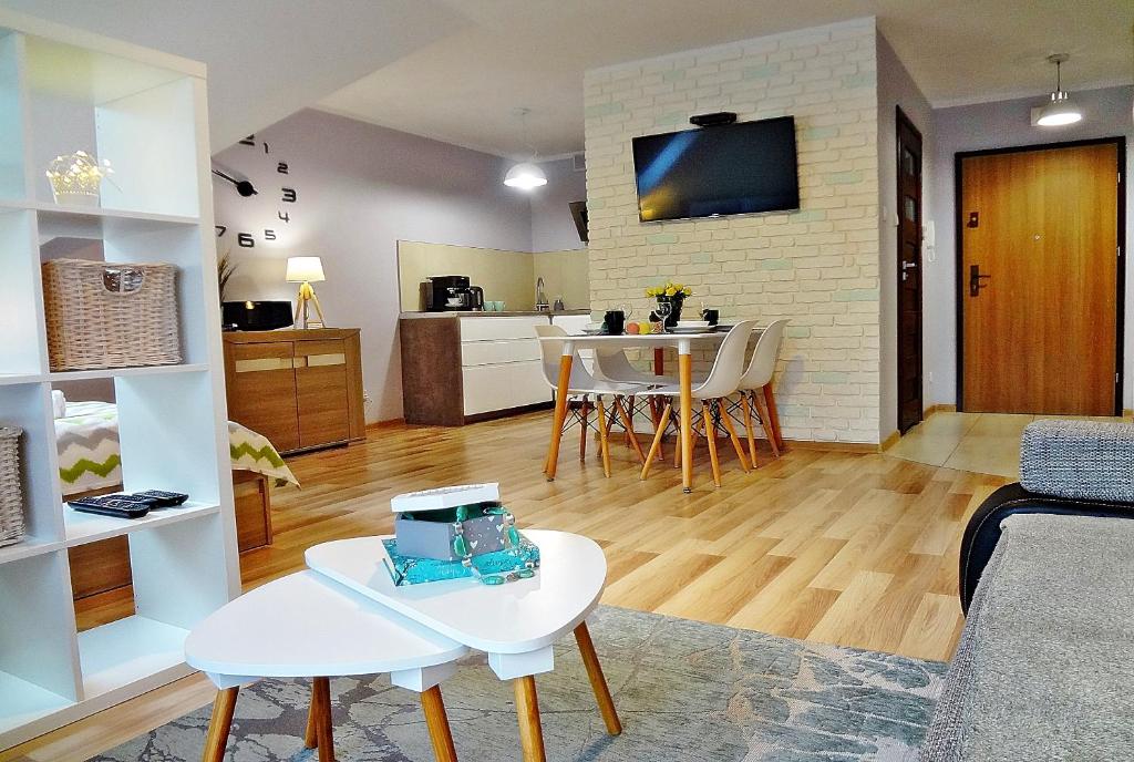 salon z kanapą i stołem w obiekcie Holiday Hill Apartamenty Pogodny w mieście Karpacz