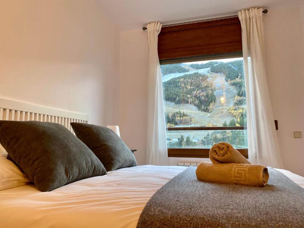 a bedroom with a bed with a large window at PROBER_SOL TARTER in El Tarter
