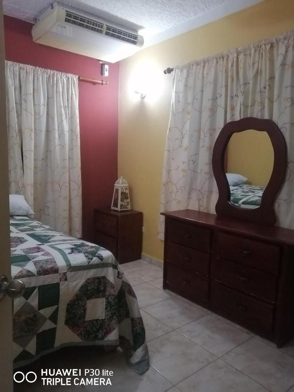 a bedroom with a bed and a dresser with a mirror at Las colinas de Samaná in Santa Bárbara de Samaná