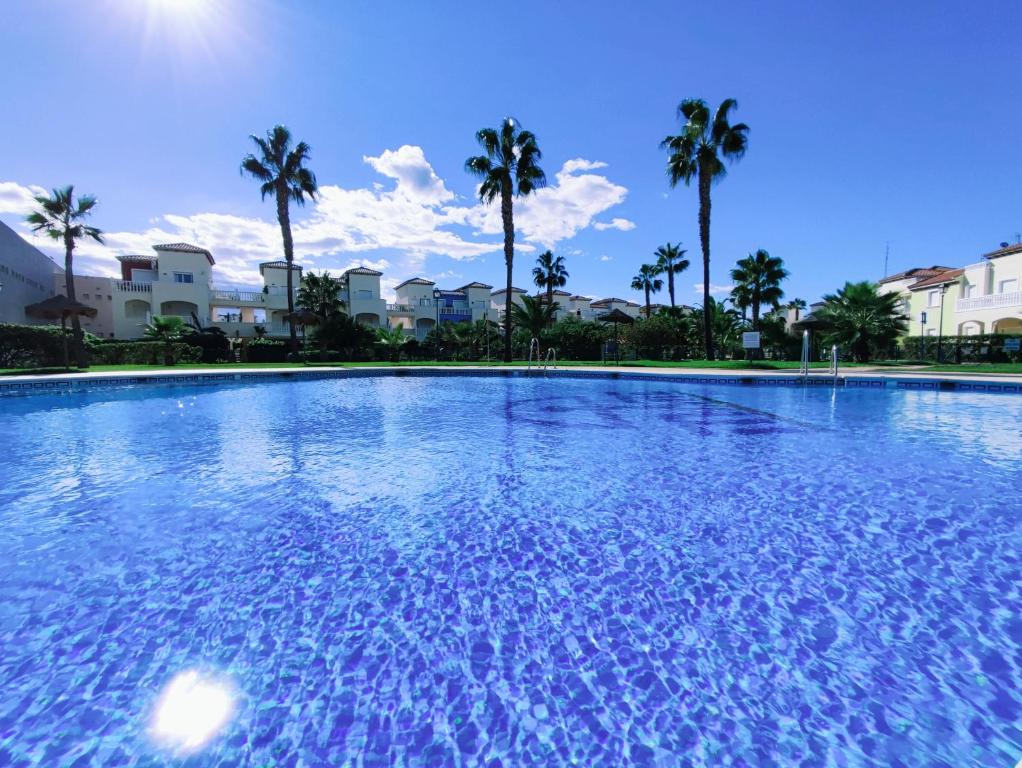 a large swimming pool with palm trees in the background at El Mirador de Torremari - Nudista - Vera playa in Vera