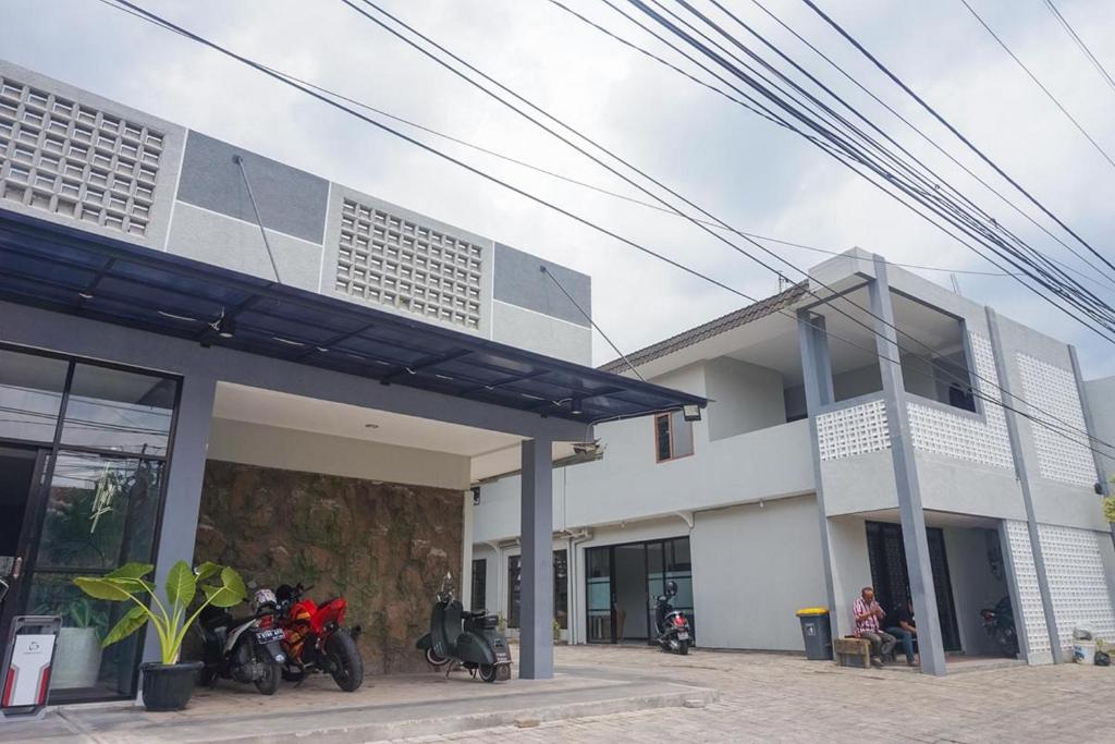 un grupo de motocicletas estacionadas fuera de un edificio en RedDoorz Plus @ Kalpataru en Rampal