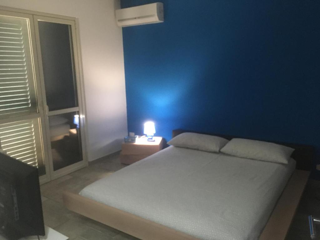 レッジョ・ディ・カラブリアにあるB&B dormirereggiocalabriaの青い壁のベッドルーム(ベッド1台付)