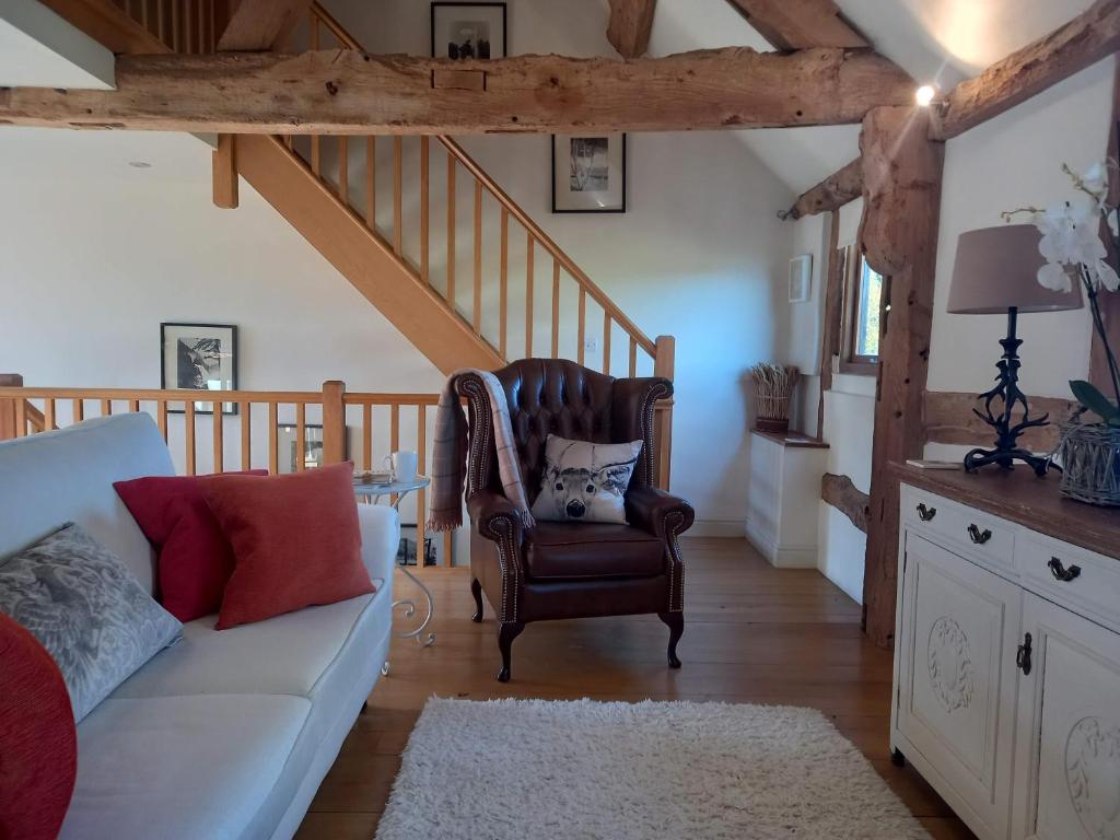 a living room with a couch and a staircase at The Barn at Titley in Kington