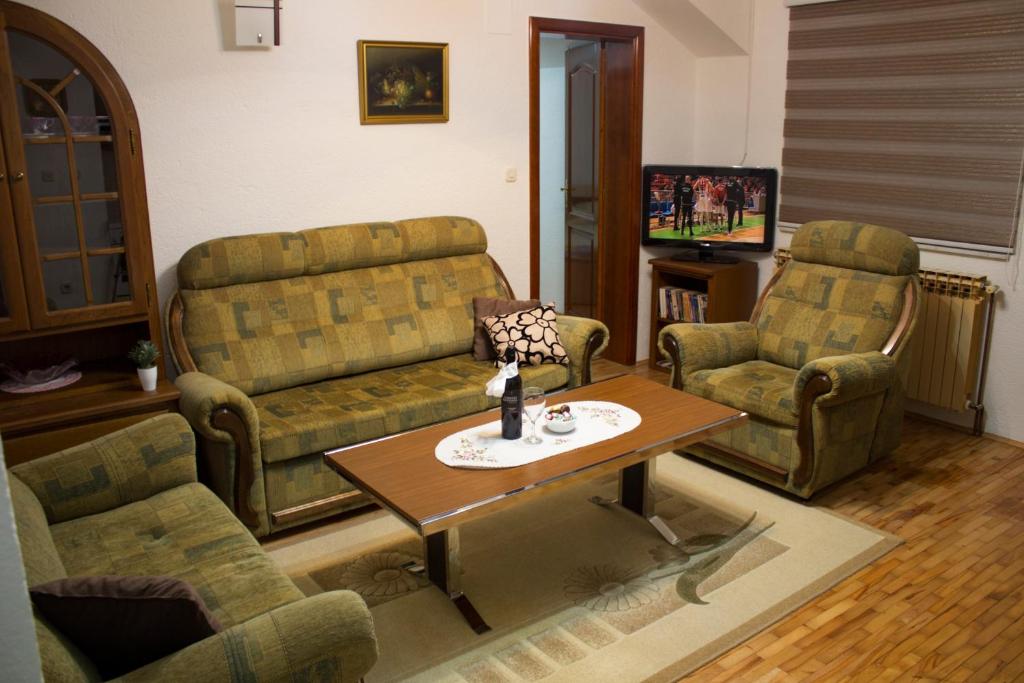 sala de estar con sofá, 2 sillas y mesa en Apartman Lotus, en Kiseljak