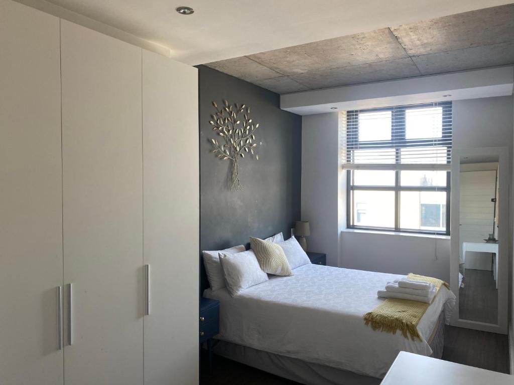 a bedroom with a bed and a window at Six One Five at Matrix in Cape Town