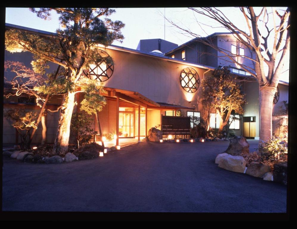 Una casa grande con luces en el lateral. en Marukyu Ryokan, en Izu