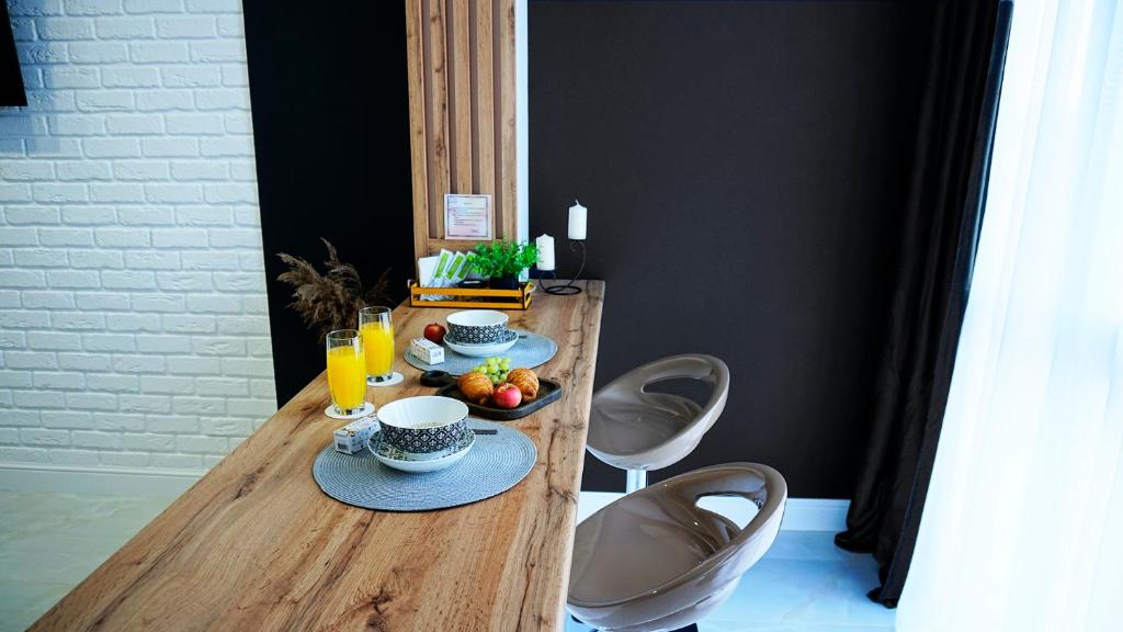 a wooden table with cups and plates of food on it at Studio Black&White in Voronezh