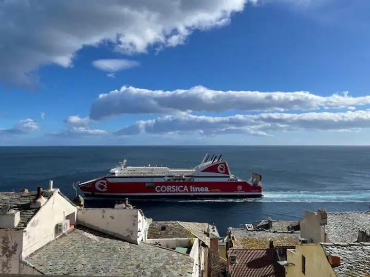 a large red boat in the water near the ocean at CASA GUASCO superbe duplex au cœur de la Citadelle, vue à 360 in Bastia