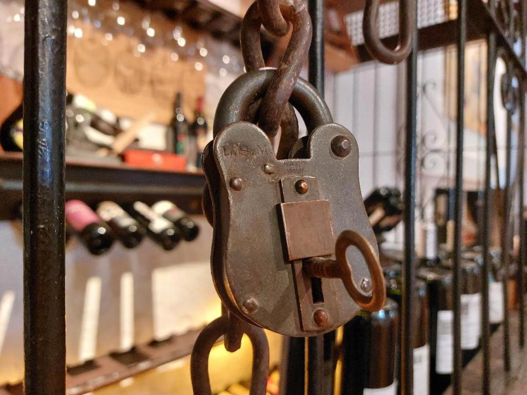 a metal padlock is attached to a rack of wine bottles at Casona en Bodega Centenaria in Guaymallen