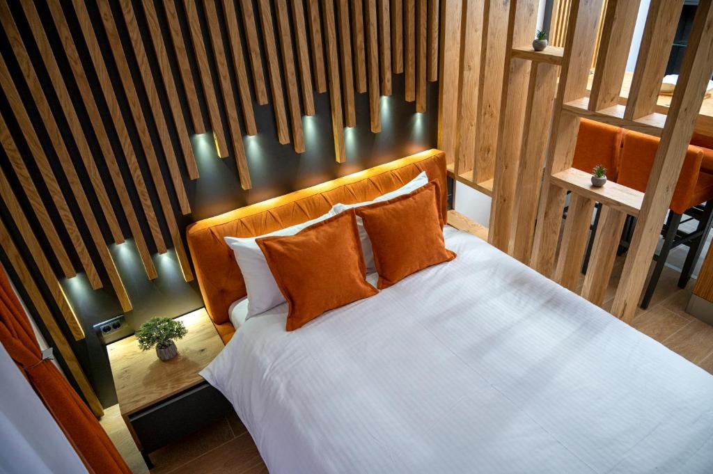 a bedroom with a white bed with orange pillows at PleasureLUX MILMARI in Kopaonik