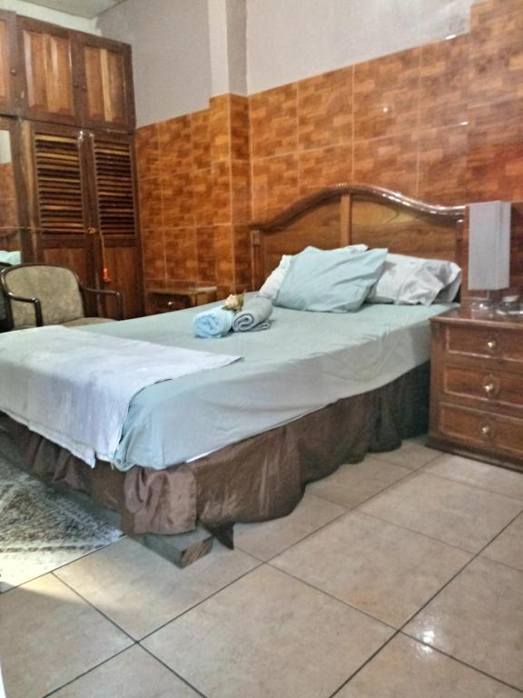 1 dormitorio con 1 cama grande y cabecero de madera en Casa Blanca Tu Casa, en Santa Ana