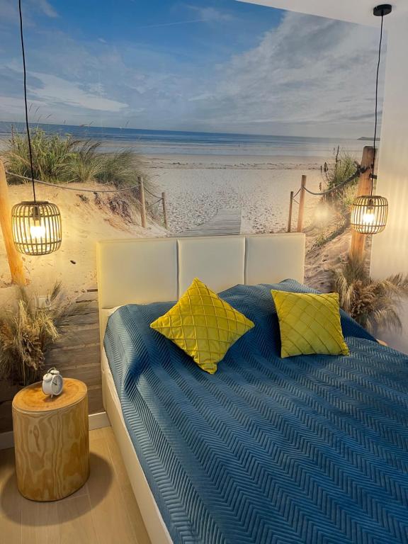 ポビエロボにあるApartament Baltic A8 Pobierowoのビーチの黄色と青の枕付きベッド