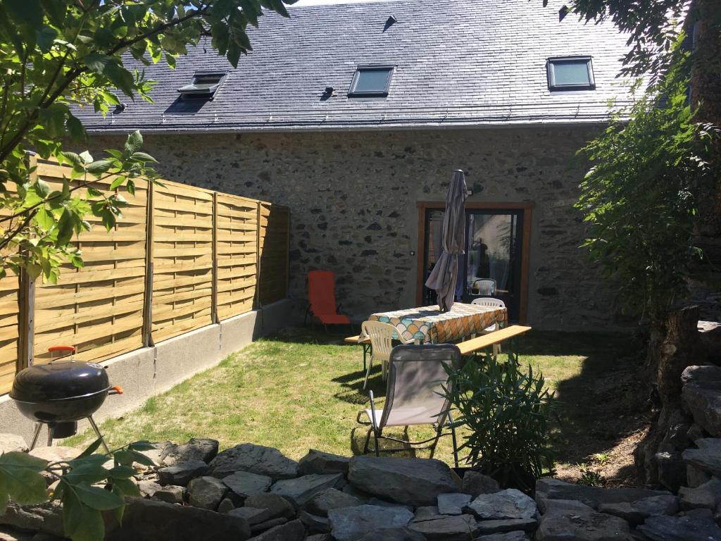 a backyard with a fence and a chair and a grill at Gîte de montagne Le Lustou in Sailhan