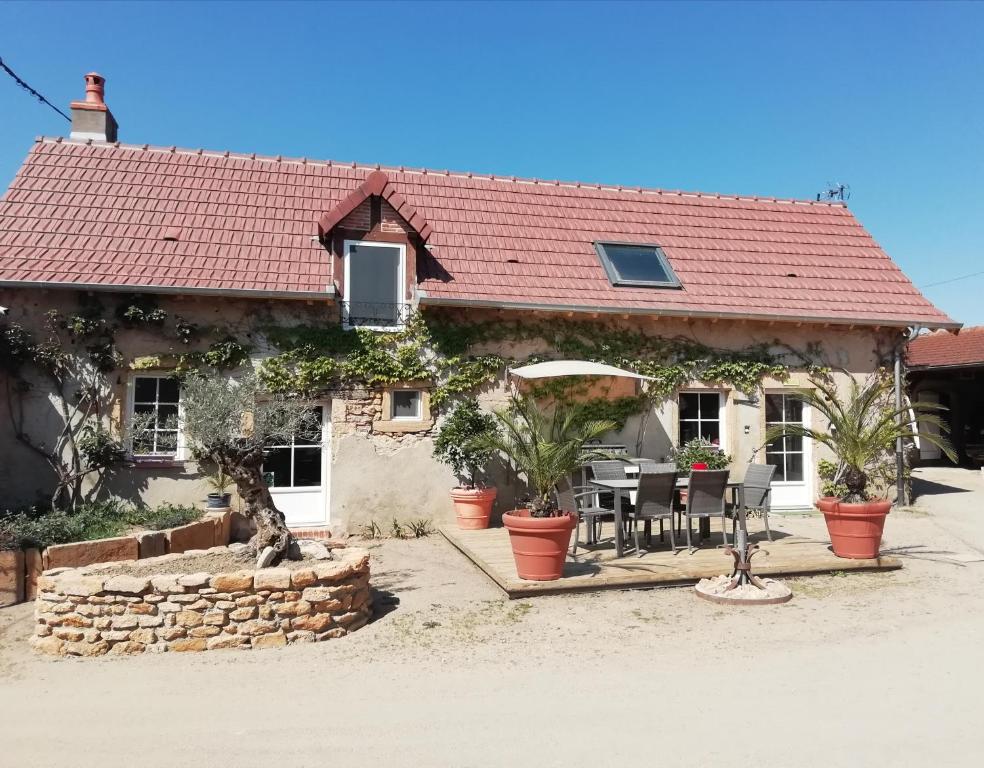 ein Haus mit einem Tisch und Stühlen davor in der Unterkunft Chambre d'hôtes Domaine de la Guinchère in LʼHôpital-le-Mercier