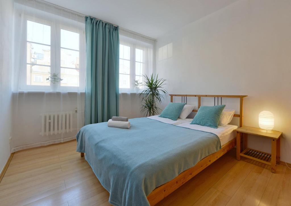ein Schlafzimmer mit einem großen Bett mit blauer Bettwäsche in der Unterkunft ARGENTIS Rynek Ratusz VI in Breslau