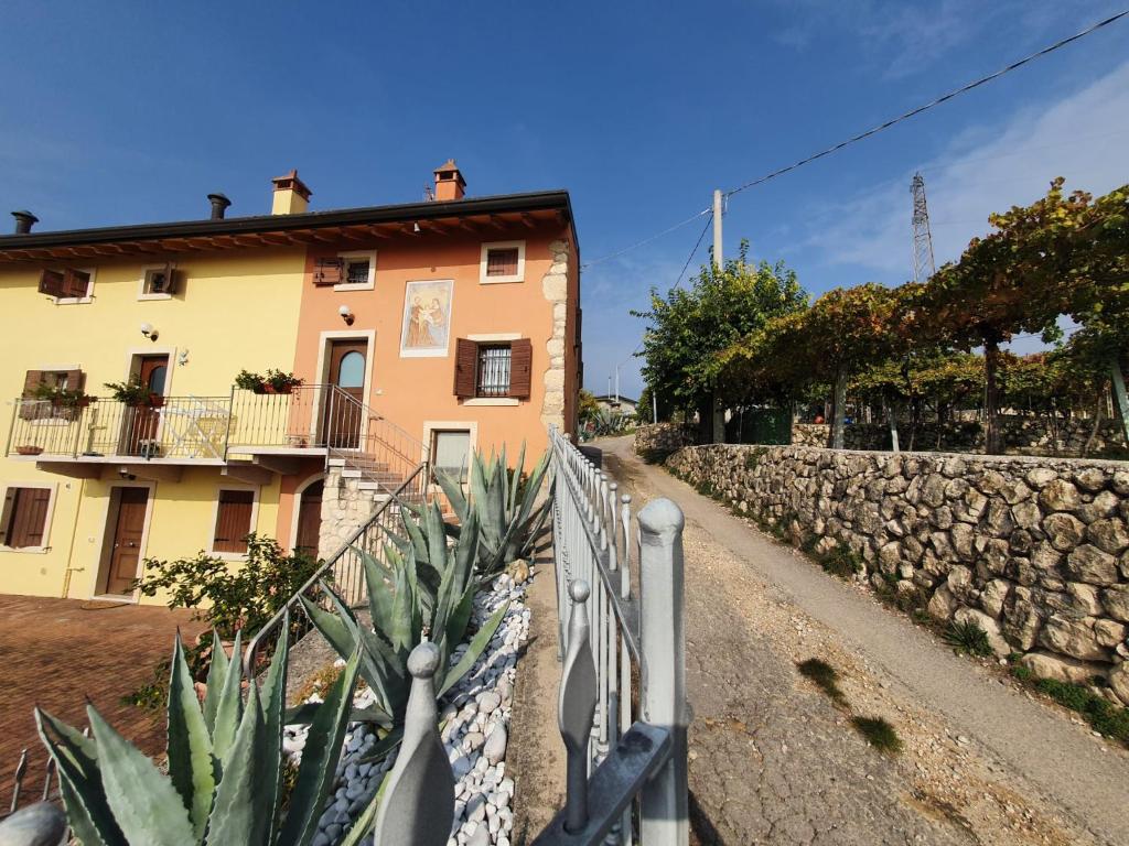 een gebouw met een hek naast een stenen muur bij L'Antico Granaio in Negrar