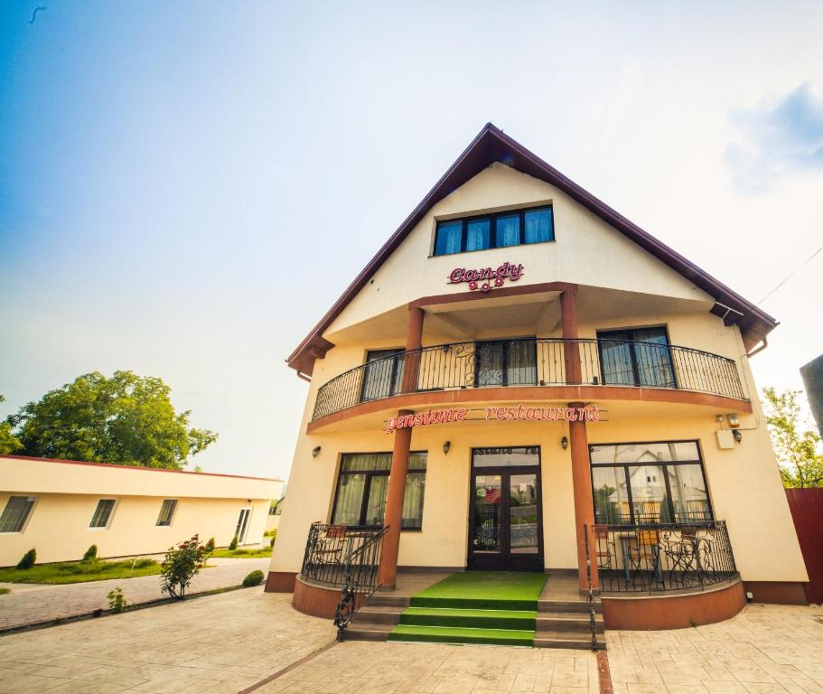 a house with a balcony on the front of it at Candy Pensiune&Restaurant in Dumbrava Roşie