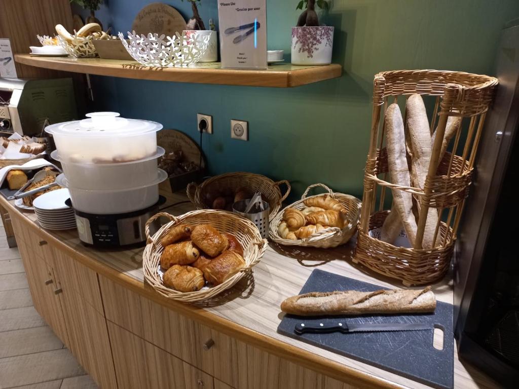 un comptoir avec des paniers et des pains dessus dans l'établissement City'O apparthotel, à Caen