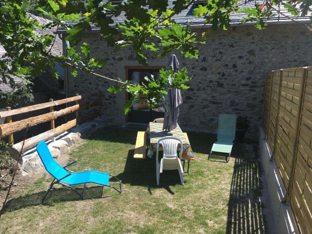 einen Garten mit einem Tisch, Stühlen und einem Sonnenschirm in der Unterkunft Gîte de montagne Le Batoua in Sailhan