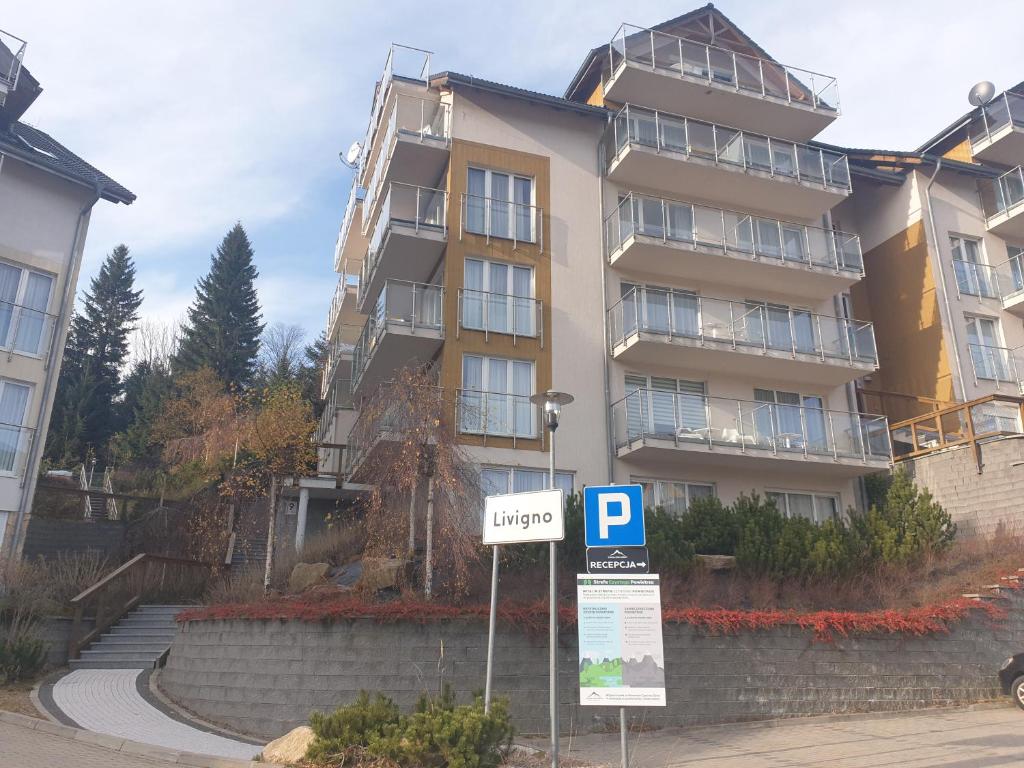 a parking sign in front of a building at Apartament Czarna Góra Faktura VAT in Sienna