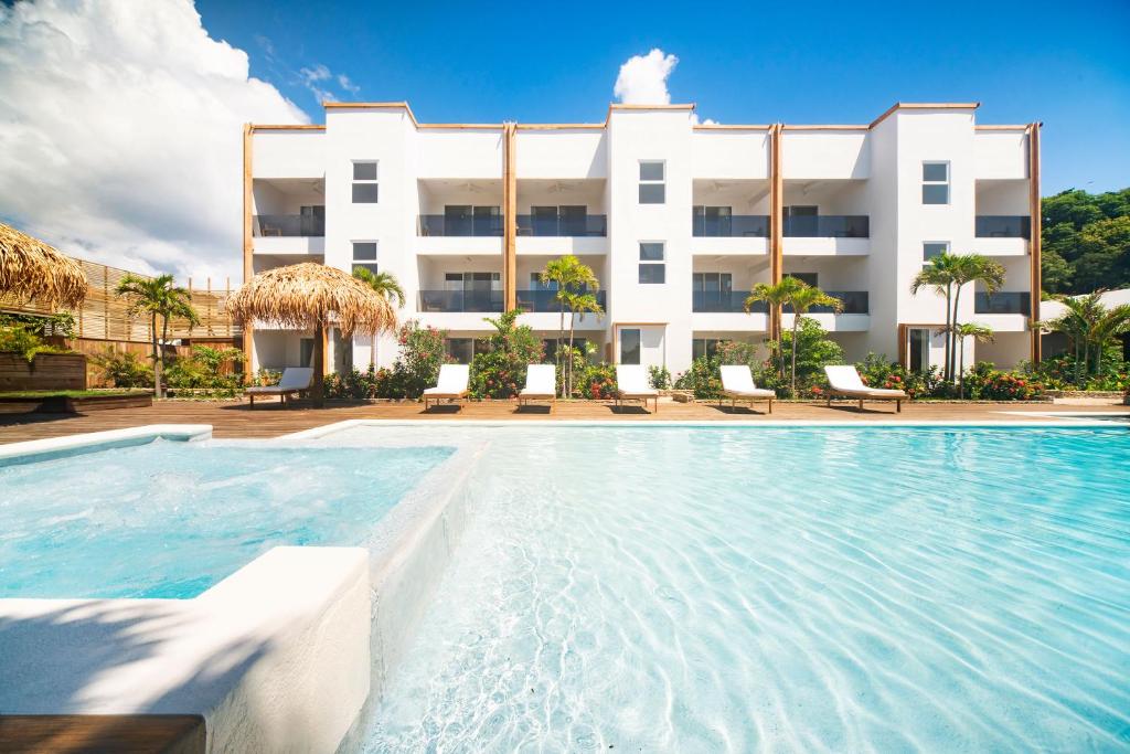 a swimming pool in front of a building at Naboo Resort & Dive Center - Adults Only in West Bay