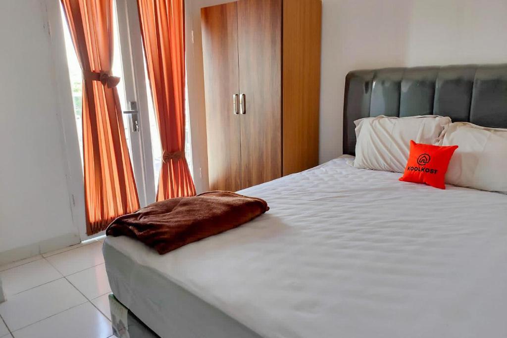 een slaapkamer met een groot bed en een oranje gordijn bij KoolKost near Millennium ICT Center Medan (Minimum Stay 6 Nights) in Pulauberayan