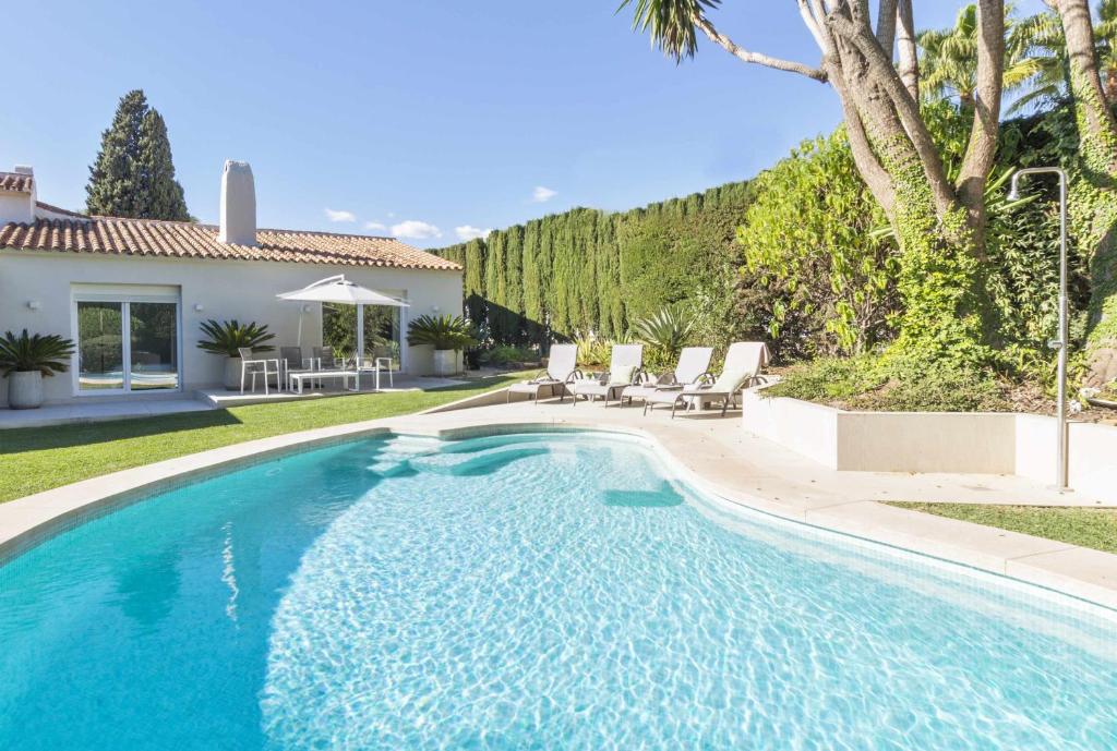 a swimming pool in the yard of a house at Villa Marvelia in Marbella