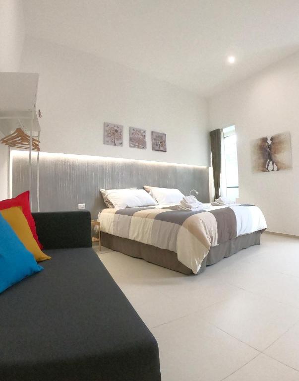 sypialnia z 2 łóżkami i kanapą w obiekcie Home Catania Dante Accommodations w Katanii