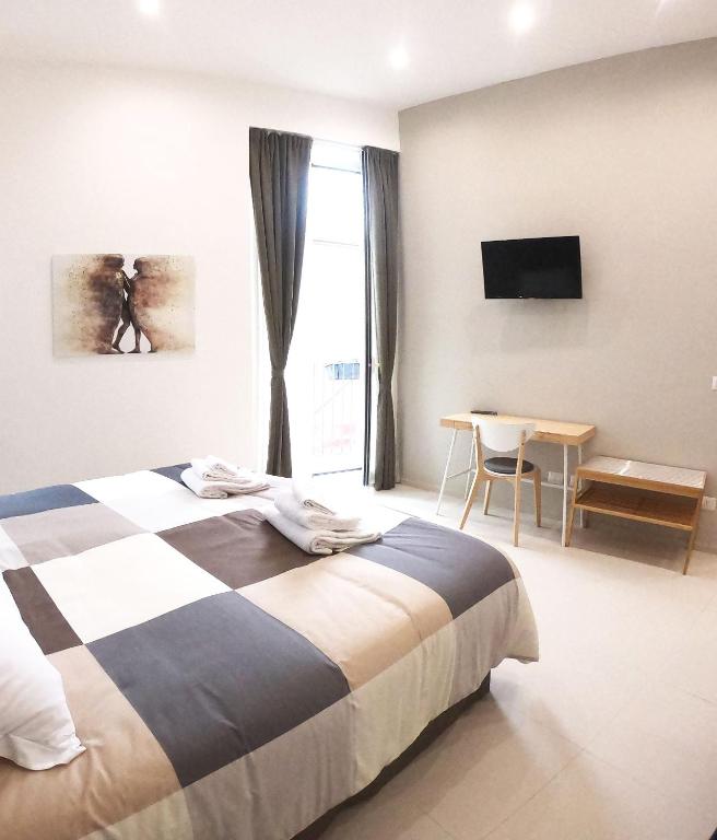 sypialnia z łóżkiem, oknem i stołem w obiekcie Home Catania Dante Accommodations w Katanii