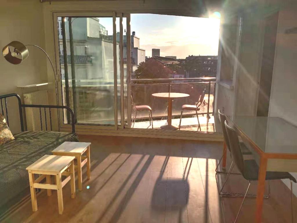 1 dormitorio con vistas a un balcón con mesa y sillas en Renovated, 37m², 2 min walk Tram, 5 min La Défense, en La Garenne-Colombes
