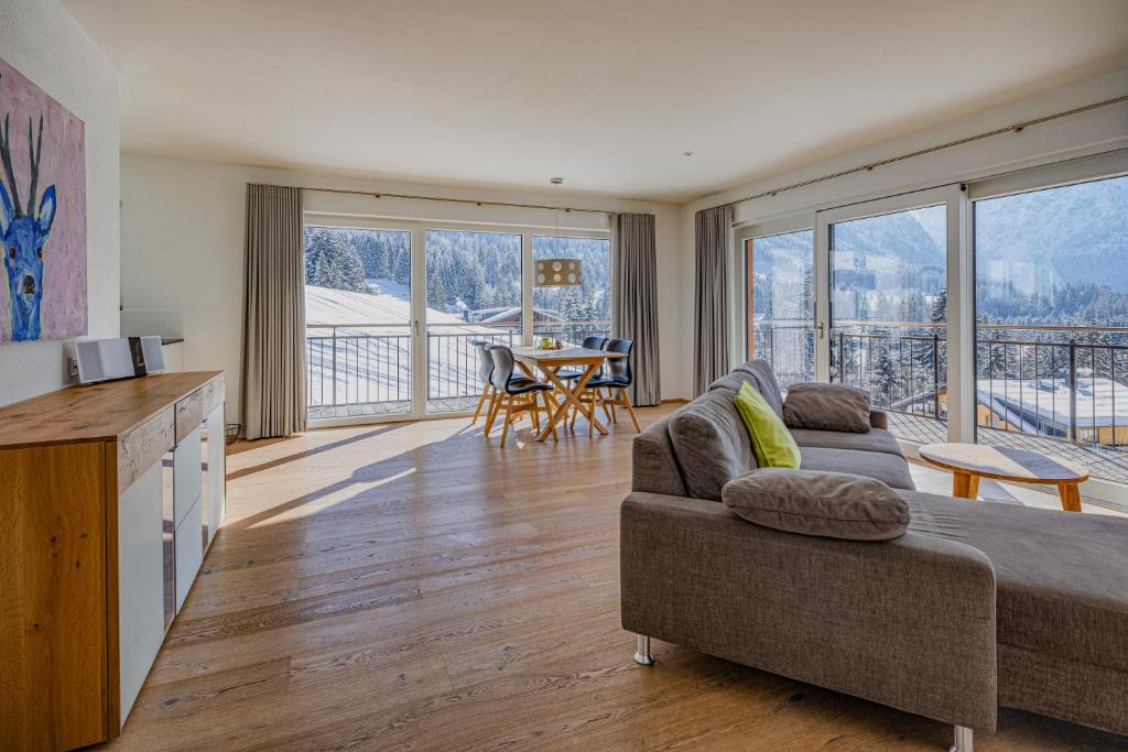 een woonkamer met een bank en een tafel bij Walser Lodge in Mittelberg