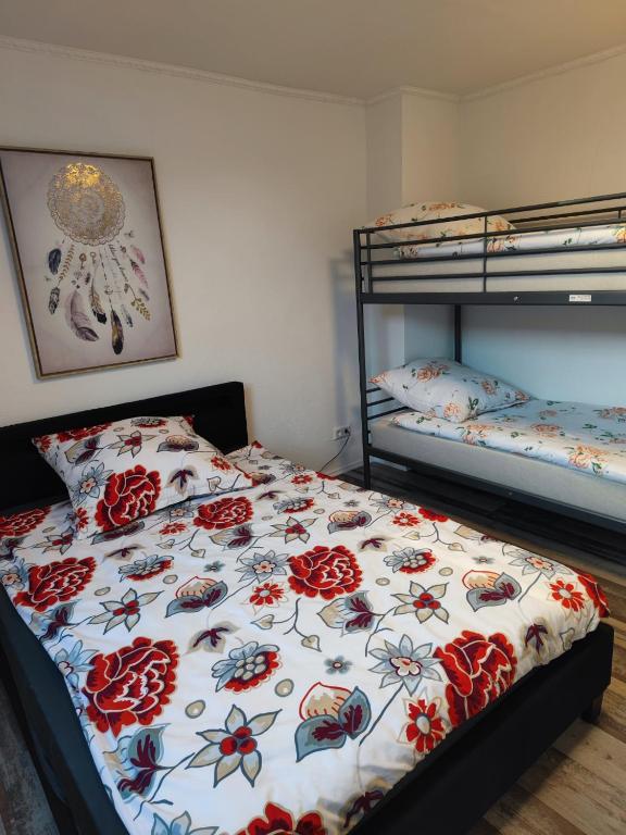 a bedroom with two bunk beds with a floral bedspread at FeWo Ammerbuch in Ammerbuch