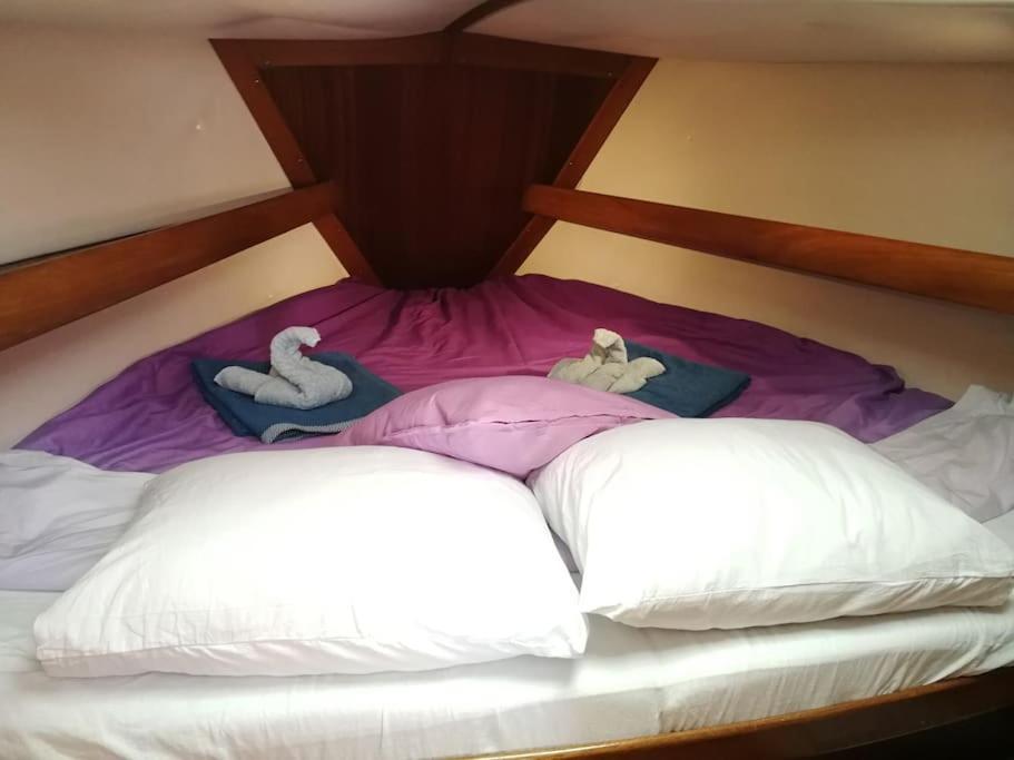 Una cama con dos almohadas con animales de peluche. en Magnifico barco en La Graciosa en Caleta de Sebo