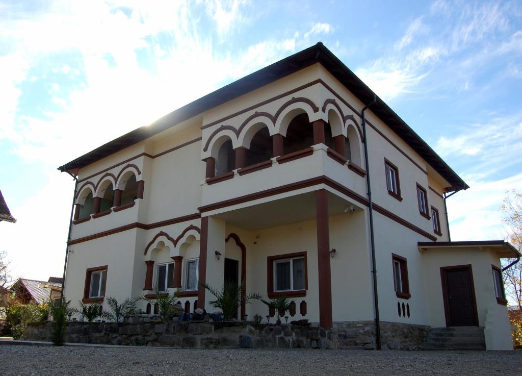 un edificio blanco con techo negro en Vila Phoenix, en Călimăneşti