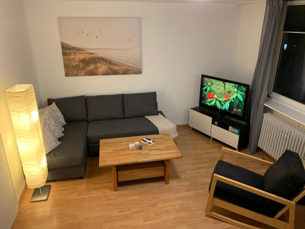 ein Wohnzimmer mit einem Sofa und einem TV in der Unterkunft Haus am Stadtrand mit super Verbindung in die City in Kassel