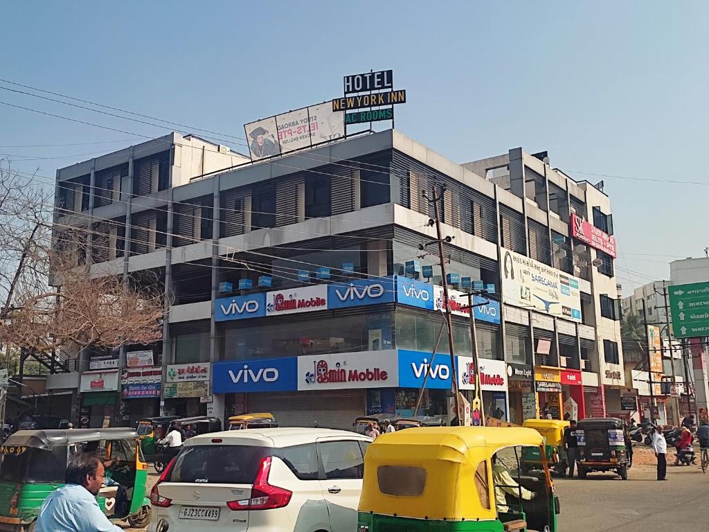 a busy city street with cars parked in front of a building at Hotel Newyork Inn in Anand