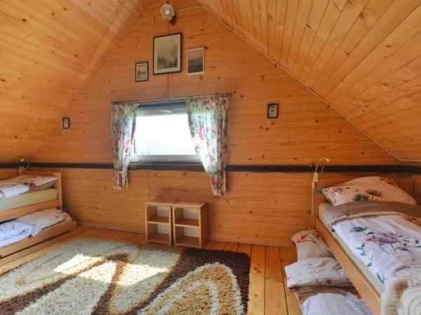 a room with two beds in a log cabin at Bieszczadzka Chatka in Smerek