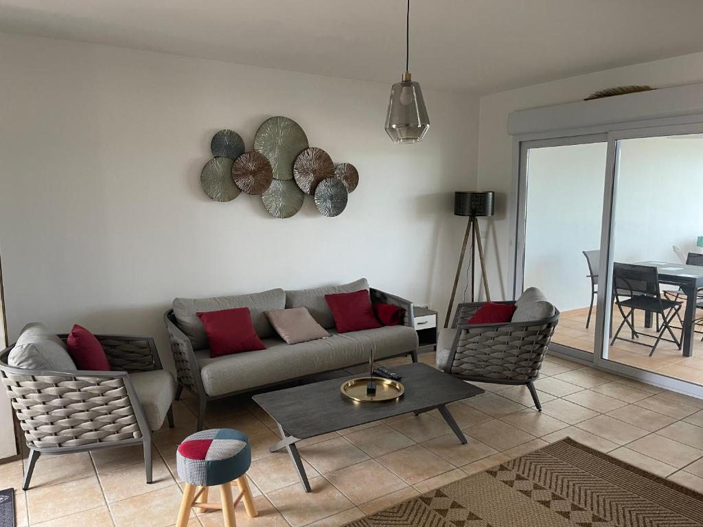 a living room with a couch and chairs and a table at TURQUOISE CARAIBES in Les Trois-Îlets