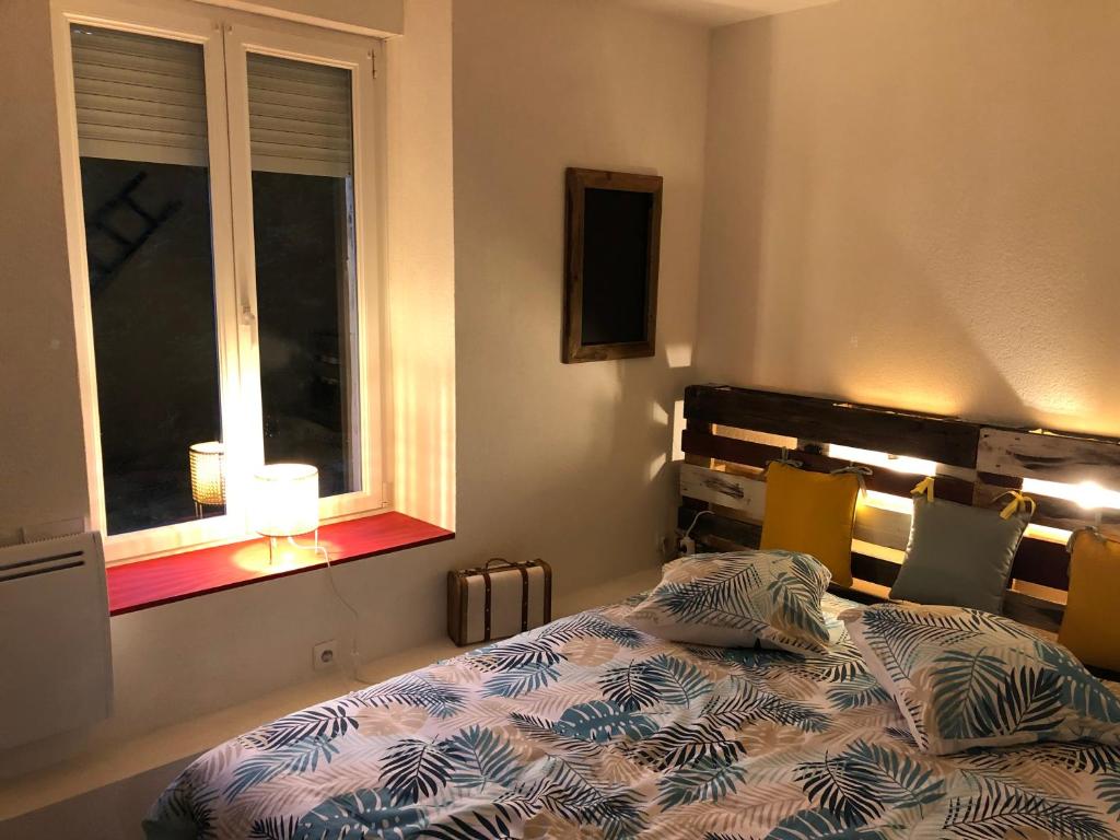 Schlafzimmer mit einem Bett und einem Fenster in der Unterkunft Chez Julien: appartement confort plein centre in Lunéville