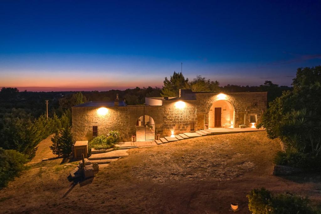 une maison en pierre éclairée la nuit dans l'établissement Masseria Luci, à Maglie