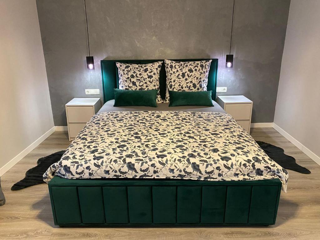 una camera con un grande letto con testiera verde di B&B Home a Sighişoara