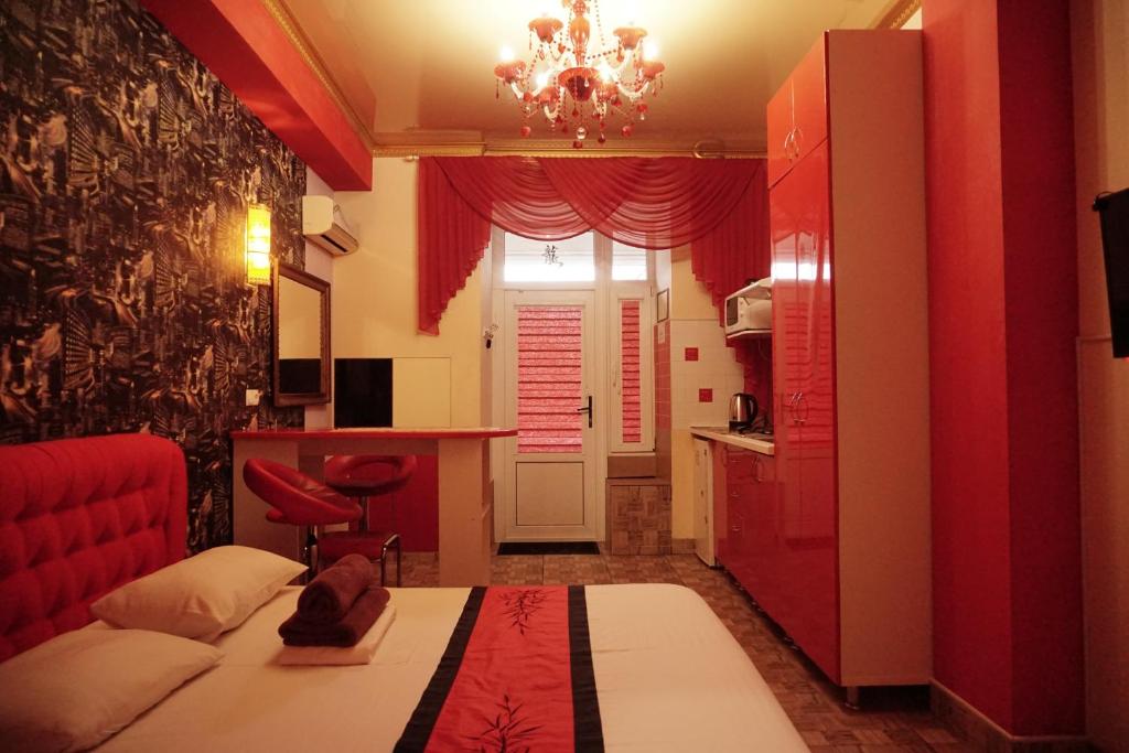 ein rotes Zimmer mit einem Bett und einer Küche in der Unterkunft Doba In Ua Yavornytskoho119 Apartments in Dnipro
